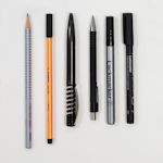 ołówek, pisak, długopis i pióro ułożone na białej powierzchni
