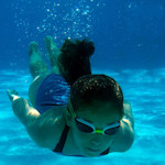 zdjęcie podwodne przedstawiające nurkującą na basenie dziewczynkę